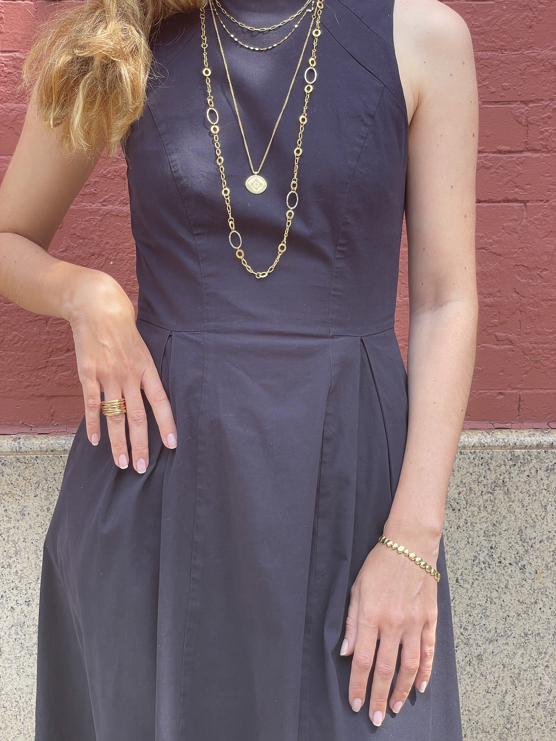 Layering gold necklaces with black dress